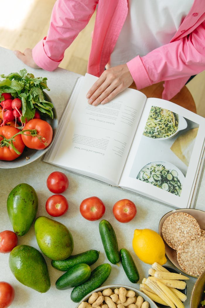 portfolio-04 Overhead view of fresh vegetables and an open cookbook on a kitchen counter.